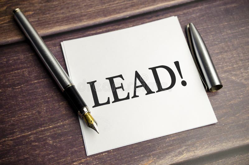 Learn and Lead Words with Pen on Brown Wooden Background Stock Image