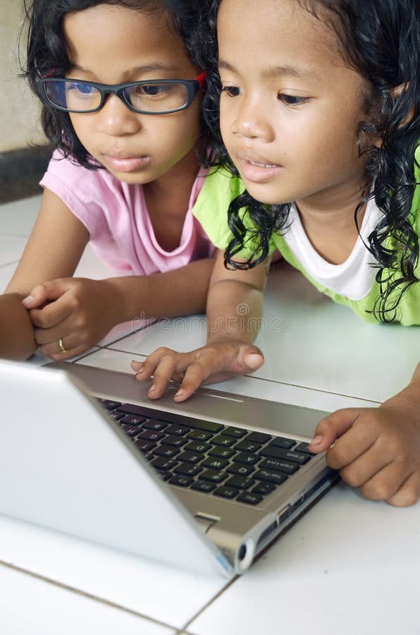 Una foto de joven las chicas divirtiéndose el estudio computadora portátil computadora.
