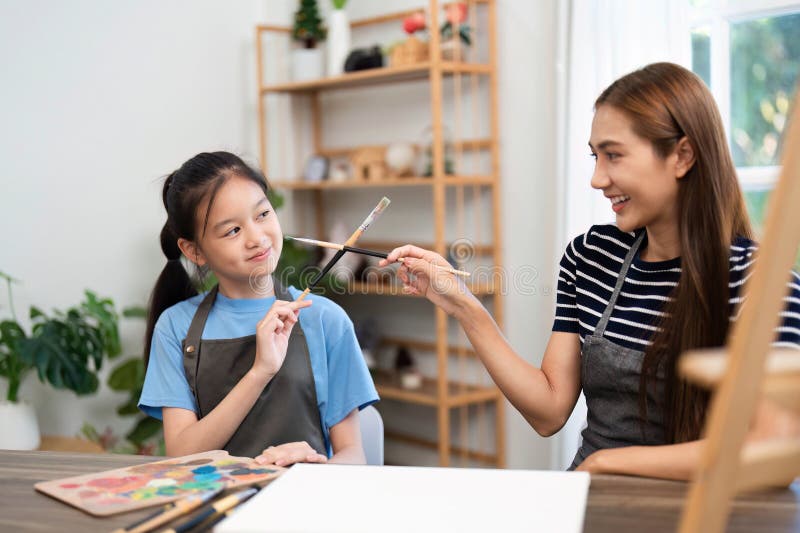 Learning together: Women and child engaging in fun painting activity royalty free stock photo