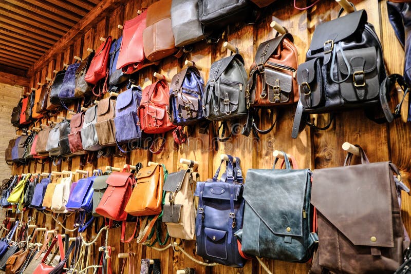 Leather backpacks and briefcases hang on the wall. The concept of stylish leather products. Bags, purses and belts. stock photography Leather backpacks and briefcases hang on the wall. The concept of stylish leather products. Bags, purses and belts. stock photography