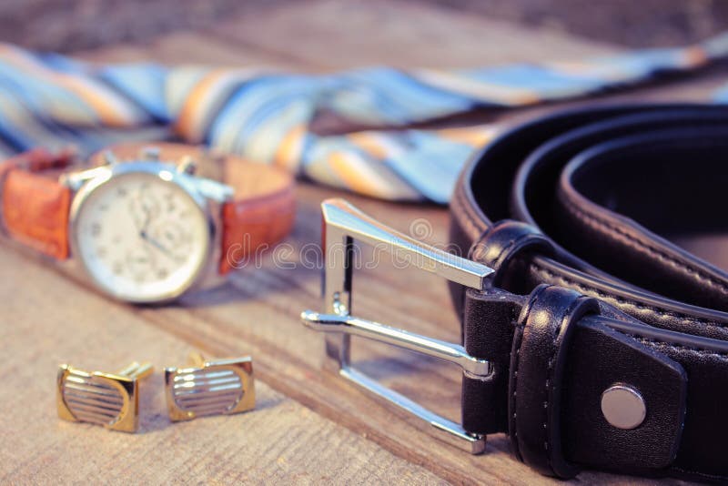 Leather belt, tie, cufflinks and watches on the old wood background. Toned image. Button clasp stock images, royalty-free photos and pictures