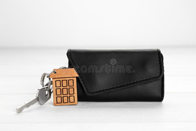 Leather case with key on white wooden table. Leather case with key on white wooden table