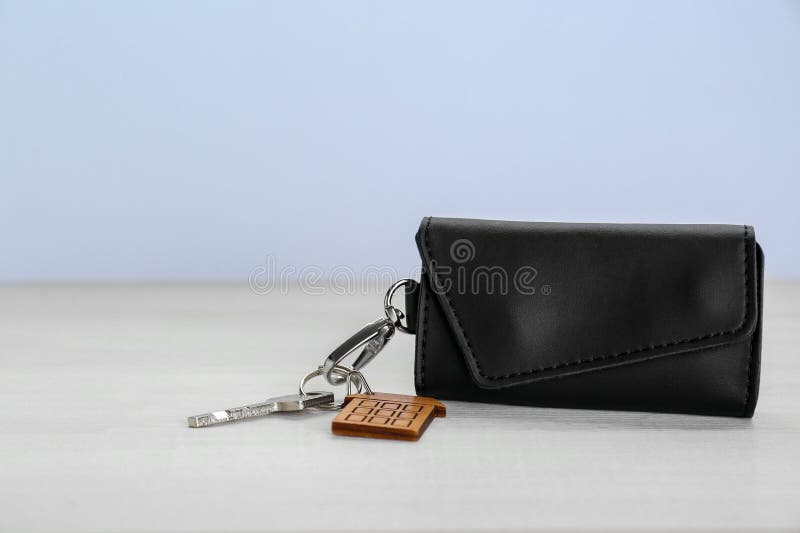 Leather case with key on white wooden table. Leather case with key on white wooden table.