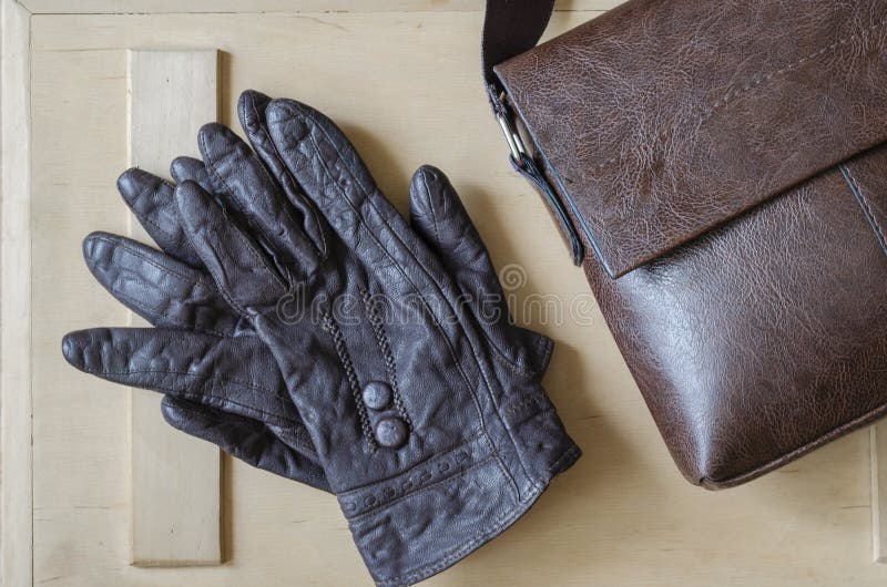 Mens Accessories With Dark Brown Leather Bags On Wooden Table Over