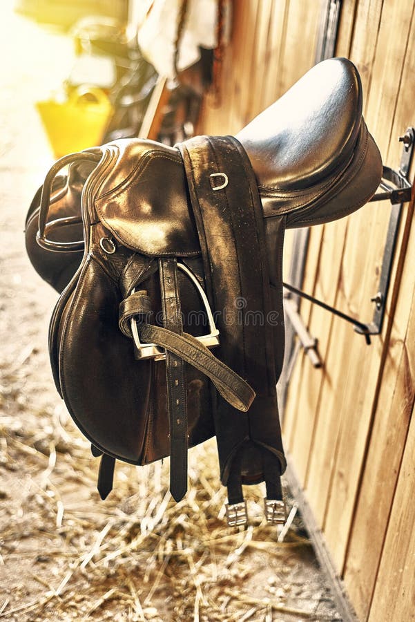 Leather Horse Saddle in a Stable Hanging on the Wall Stock Image