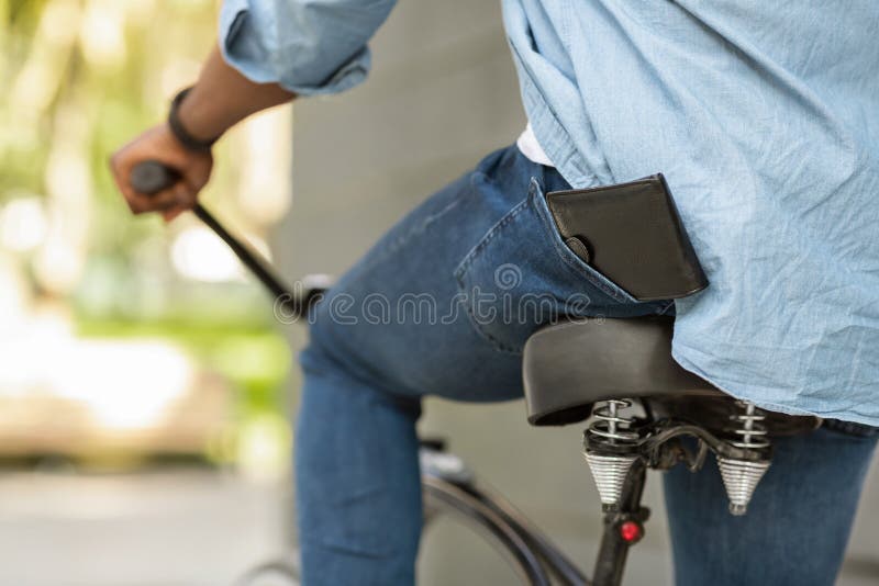 Wallet Falling Down From Pocket Of Unrecognizable Afro Guy On Bike stock photos