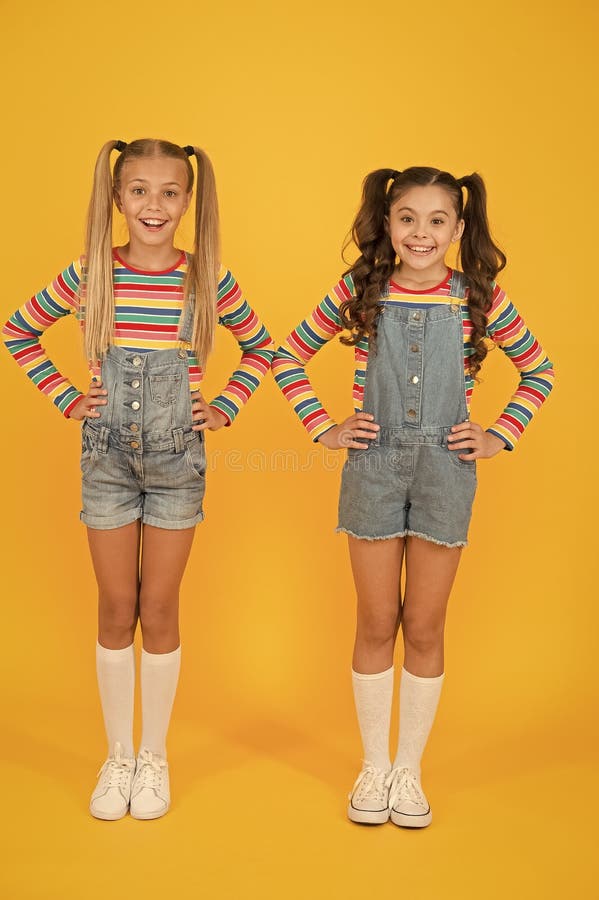 Lebhafte Farben. moderne Mode. Kindermode. Mädchen lange Haare. niedliche Kinder gleiche Outfits. kleine Mädchen mit Regenbogen stockfotos