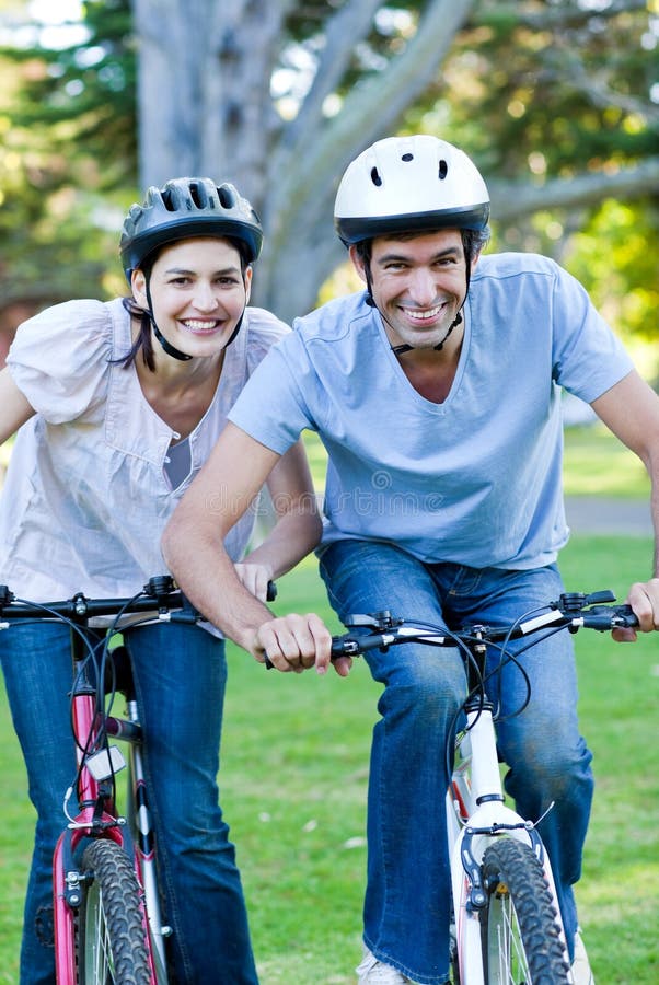 Lebhafte Paare, die ein Fahrrad reiten