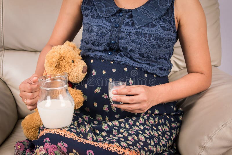 Leche de consumo de las mujeres embarazadas fotografía de archivo libre de regalías Leche de consumo de las mujeres embarazadas fotografía de archivo libre de regalías