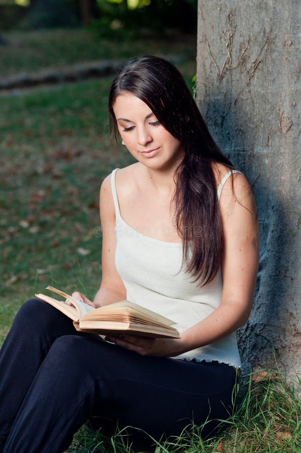 Beautiful girl reading a book in the park. Beautiful girl reading a book in the park