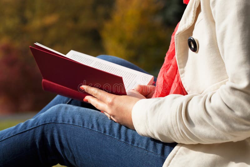 Close up of woman reading book outside dressed in coat. Close up of woman reading book outside dressed in coat