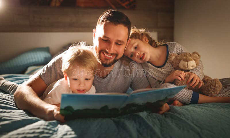 Lectura de la familia de la tarde el padre lee a niños libro antes del goin
