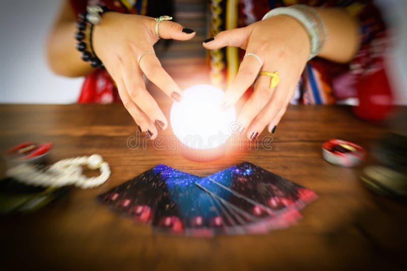 Psychic readings and clairvoyance concept / Crystal ball fortune teller hands and Tarot cards reading divination. Psychic readings and clairvoyance concept / Crystal ball fortune teller hands and Tarot cards reading divination