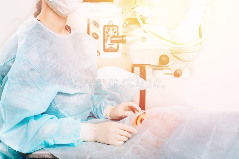 Leczenia na Lasik Laserowa korekcja wzroku Lekarz bada dna w mikroskopie, pacjent pod sterylną osłoną fotografia royalty free Leczenia na Lasik Laserowa korekcja wzroku Lekarz bada dna w mikroskopie, pacjent pod sterylną osłoną fotografia royalty free