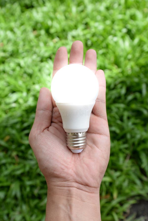 LED bulb - Energy in our hand with lighting royalty free stock photography