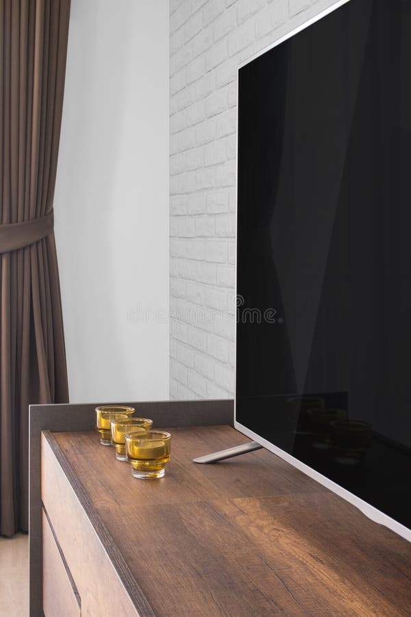 Led TV on TV Stand with Candles and Curtain, White Brick Wall Stock