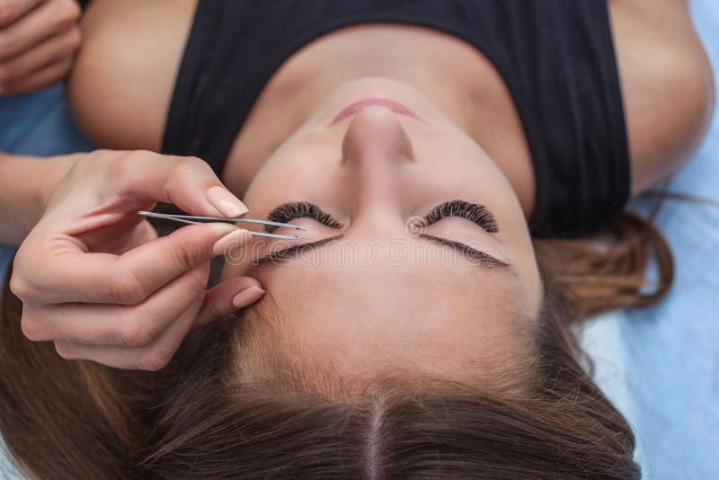 Ledar- makeup korrigerar och ger form för att dra ut med kirurgisk tång som målas föregående med hennaögonbryn i en skönhetsalong fotografering för bildbyråer Ledar- makeup korrigerar och ger form för att dra ut med kirurgisk tång som målas föregående med hennaögonbryn i en skönhetsalong fotografering för bildbyråer
