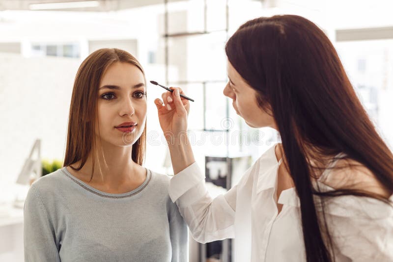 Ledar- makeup korrigerar och ger form för ögonbryn i en skönhetsalong royaltyfri fotografi Ledar- makeup korrigerar och ger form för ögonbryn i en skönhetsalong royaltyfri fotografi