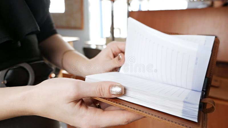 Lederen dagboekdemonstratie in de handen van een vrouw. lederwerkplaats