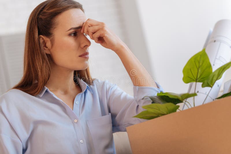 Ledsen arbetslös kvinna som försöker att inte gråta, medan sitta hemma