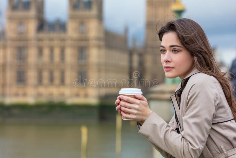 Ledsen fundersam kvinna som dricker kaffe i London vid Big Ben royaltyfri foto Ledsen fundersam kvinna som dricker kaffe i London vid Big Ben royaltyfri foto