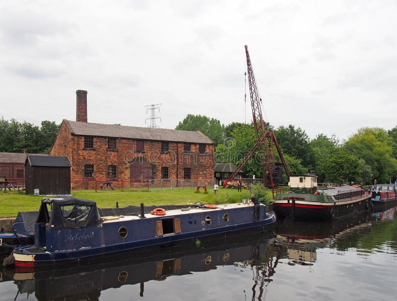 Houseboats moored outside thwaite mill in knostrop leeds with people on boats and historic watermill in the background