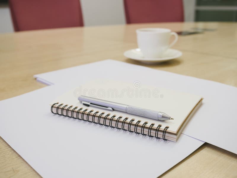 Leeg notaboek met pen en koffie, Bedrijfsvergaderzaal royalty-vrije stock afbeelding Leeg notaboek met pen en koffie, Bedrijfsvergaderzaal royalty-vrije stock afbeelding