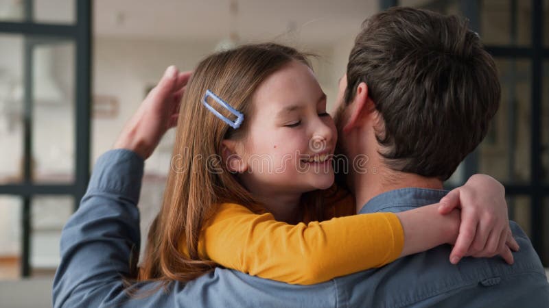 Leende kaukasisk familj som tar hand om far, manliga föräldrar som kramar och tar hand om små flickbarnlycka hemma. glad lager videofilmer
