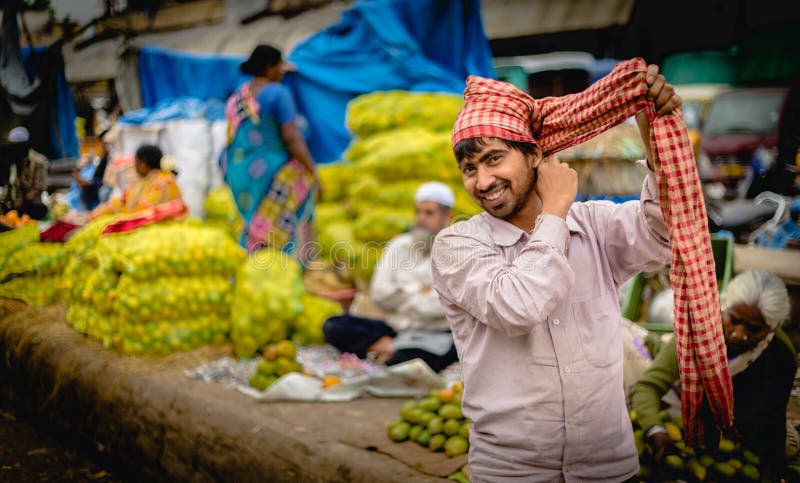 Leende män som säljer grönsaker och frukt på marknaden i Bangalore