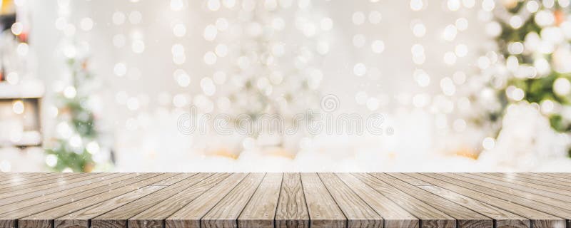 Leer woooden Tischplatte mit abstraktem warmem Wohnzimmerdekor mit hellem Unschärfehintergrund der Weihnachtsbaum-Kette mit Schne