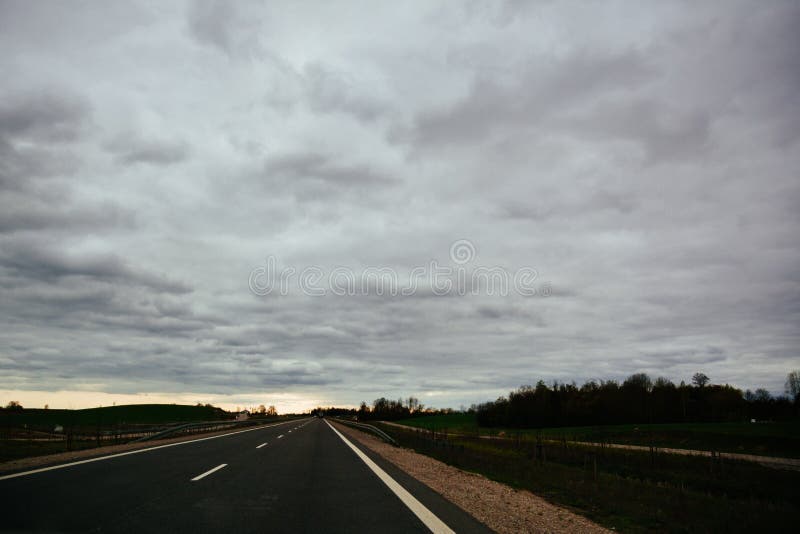 Leere Asphaltstraße am bewölkten Sommertag in Litauen stockfotografie Leere Asphaltstraße am bewölkten Sommertag in Litauen stockfotografie