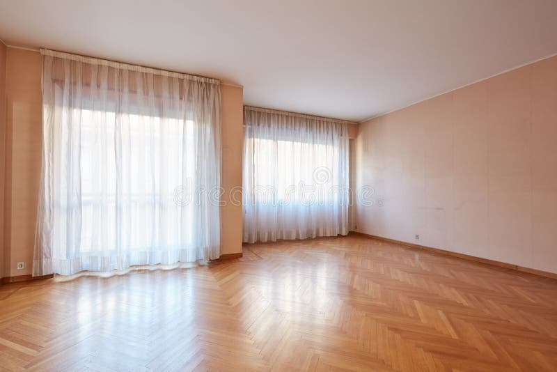 Leere großer Raum mit Parkett und weißen Vorhängen im Wohnungsinnenraum stockbild