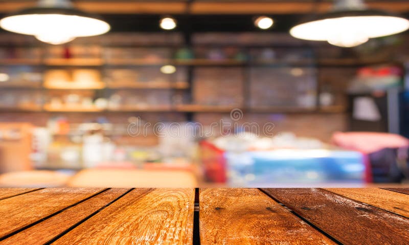 Leere hölzerne Tabelle und Kaffeestube verwischen Hintergrund mit bokeh imag