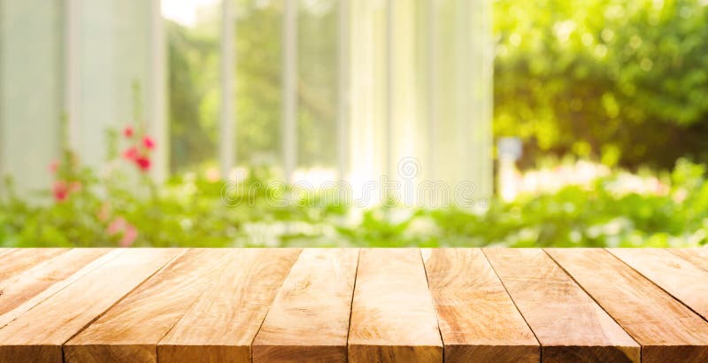 Leere hölzerne Tischplatte auf Unschärfezusammenfassungsgrün vom Garten