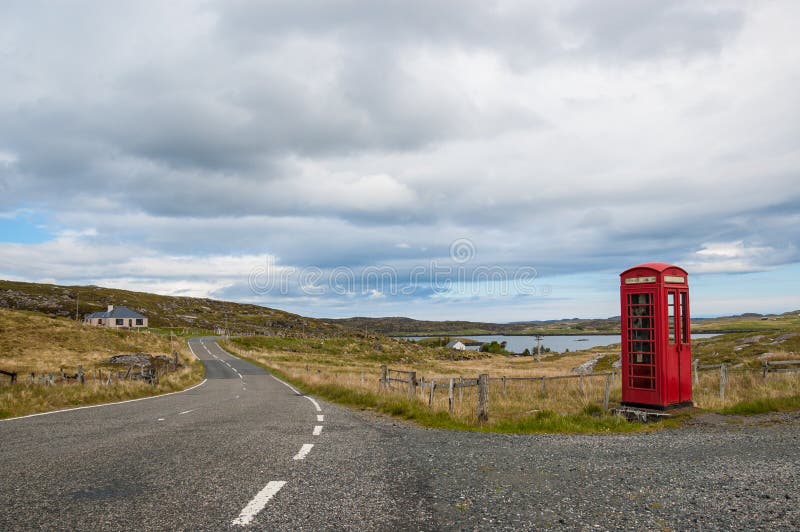 Leere Landschaftsstraße mit britischer roter Telefonzelle lizenzfreie stockfotografie