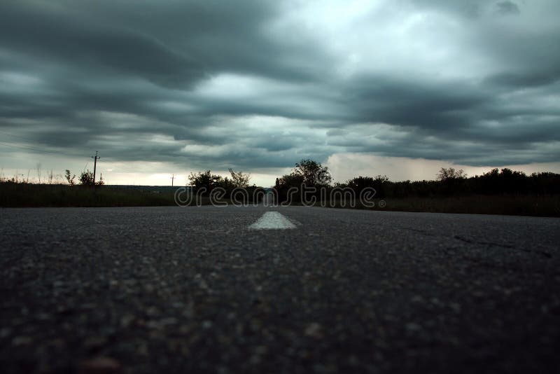 Leere Landschaftsstraße unter stürmischem Himmel lizenzfreie stockfotografie