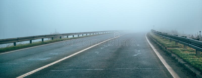 Leere Landstraße im nebligen Wintermorgen lizenzfreies stockfoto