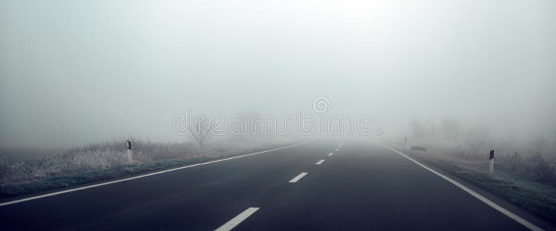 Leere Landstraße im nebligen Wintermorgen lizenzfreies stockfoto