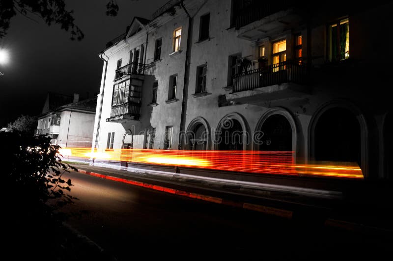 Leere Nachtstraße einer europäischen Stadt mit kleinen Häusern, Auto beleuchtet in der Unschärfe lizenzfreie stockfotos Leere Nachtstraße einer europäischen Stadt mit kleinen Häusern, Auto beleuchtet in der Unschärfe lizenzfreie stockfotos
