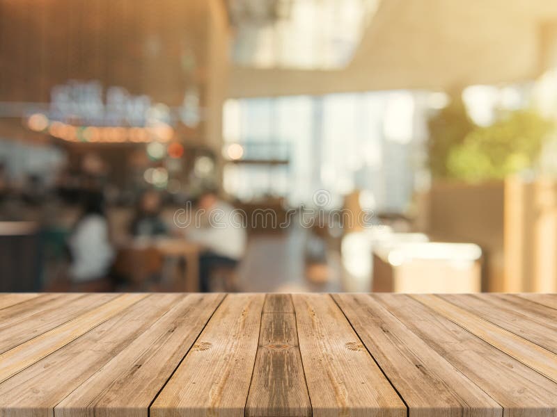 Leere Tischplatte des hölzernen Brettes an unscharfer Hintergrund Braune hölzerne Tabelle der Perspektive über Unschärfe im Kaffe lizenzfreie stockfotos
