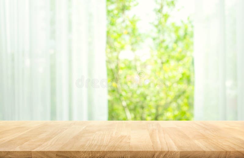 Leeren Sie sich von der hölzernen Tischplatte auf Unschärfe des Vorhangs mit Fensteransichtgrün vom Baumgartenhintergrund lizenzfreies stockbild Leeren Sie sich von der hölzernen Tischplatte auf Unschärfe des Vorhangs mit Fensteransichtgrün vom Baumgartenhintergrund lizenzfreies stockbild