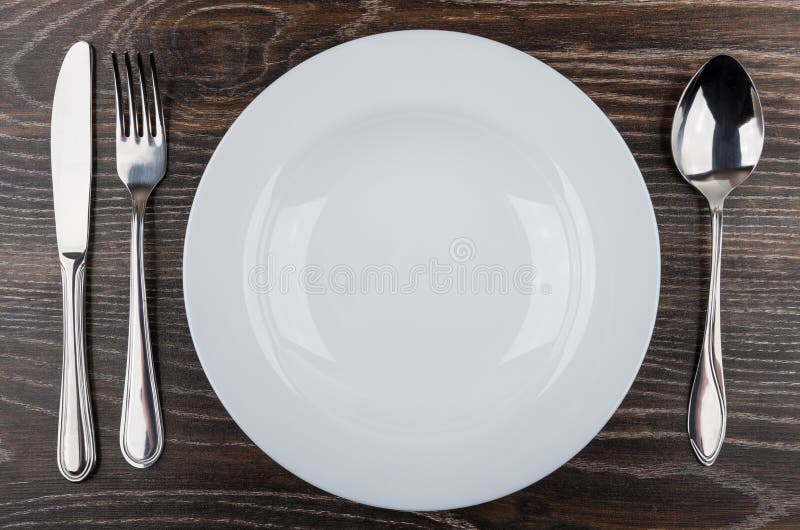 Leeren Sie weiße Platte, Messer, Gabel und Löffel auf Tabelle lizenzfreies stockbild Leeren Sie weiße Platte, Messer, Gabel und Löffel auf Tabelle lizenzfreies stockbild