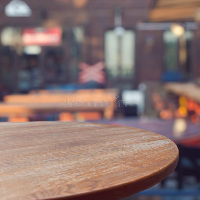 Leerer hölzerner Rundtisch über Restauranthintergrund im Freien stockfoto Leerer hölzerner Rundtisch über Restauranthintergrund im Freien stockfoto