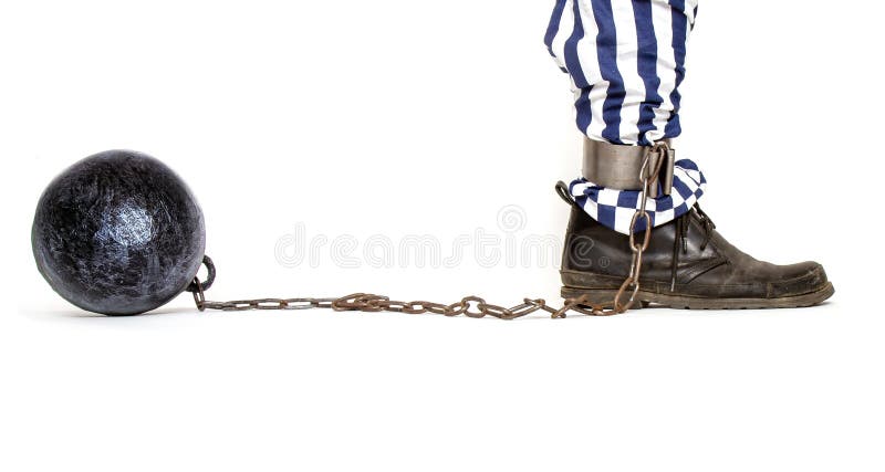 Leg of a prisoner in striped pants and a rough boot chained with an iron ball with shackles in profile