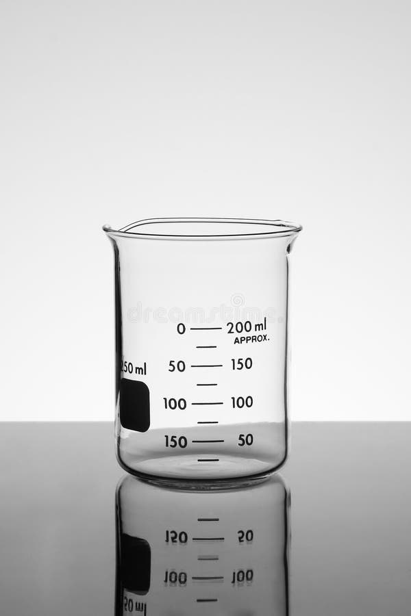 An empty beaker resting on a mirrored table with light grey background. An empty beaker resting on a mirrored table with light grey background.