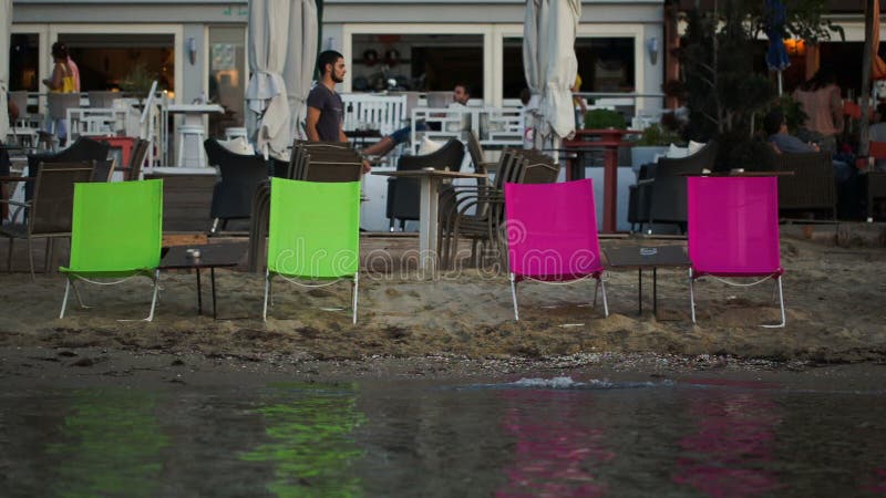 Lege chaise-zitkamers op het strand en de openluchtkoffie