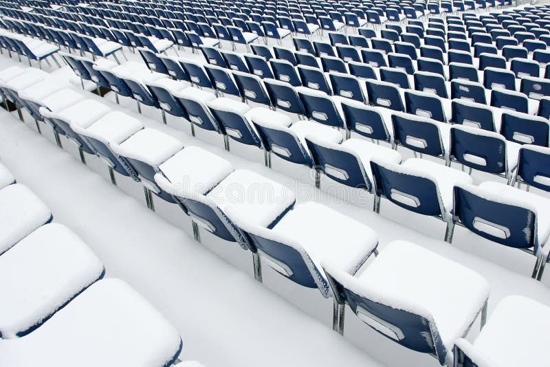 Lege plastic die stoelen in sneeuw worden behandeld royalty-vrije stock foto Lege plastic die stoelen in sneeuw worden behandeld royalty-vrije stock foto