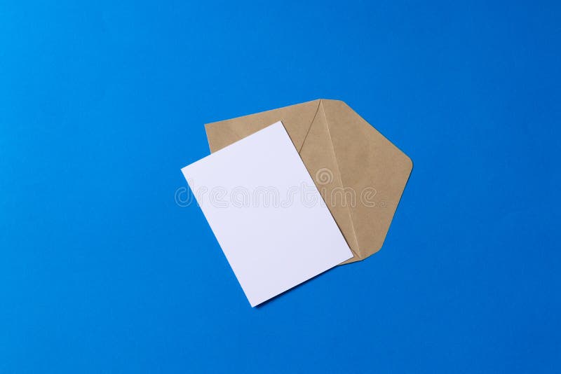 Lege witte kaart met van de het pakpapierenvelop van kraftpapier het malplaatje omhoog spot stock afbeelding Lege witte kaart met van de het pakpapierenvelop van kraftpapier het malplaatje omhoog spot stock afbeelding
