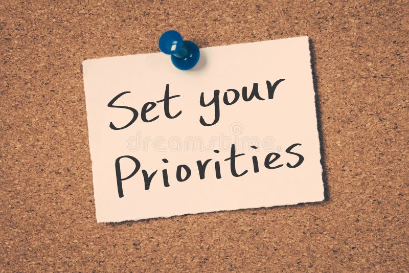 Set your priorities concept reminder message on a cork board. Set your priorities concept reminder message on a cork board