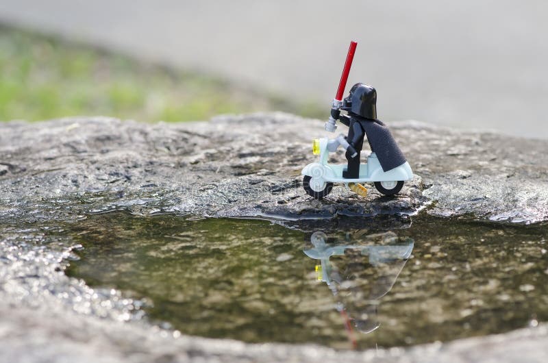 Lego dara βαντέρ σκούτερ κρατώντας το φως σπαθιά κοντά στη λίμνη με αντανάκλαση στοκ εικόνα με δικαίωμα ελεύθερης χρήσης